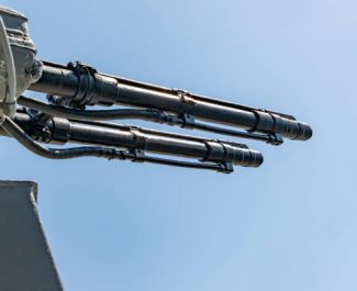 Close-up of a tower with a ship gun. Ship weapon tower. Naval exercises, attack, and defense.